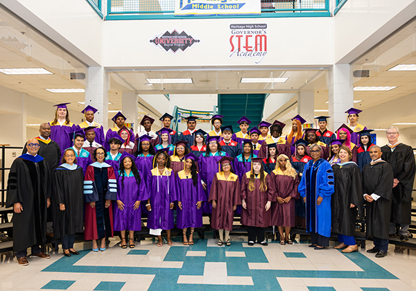 Graduating students and staff in group photo during graduation ceremony.