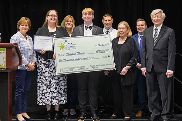 Mr. Wennin accepting award check surrounded by dignitaries.